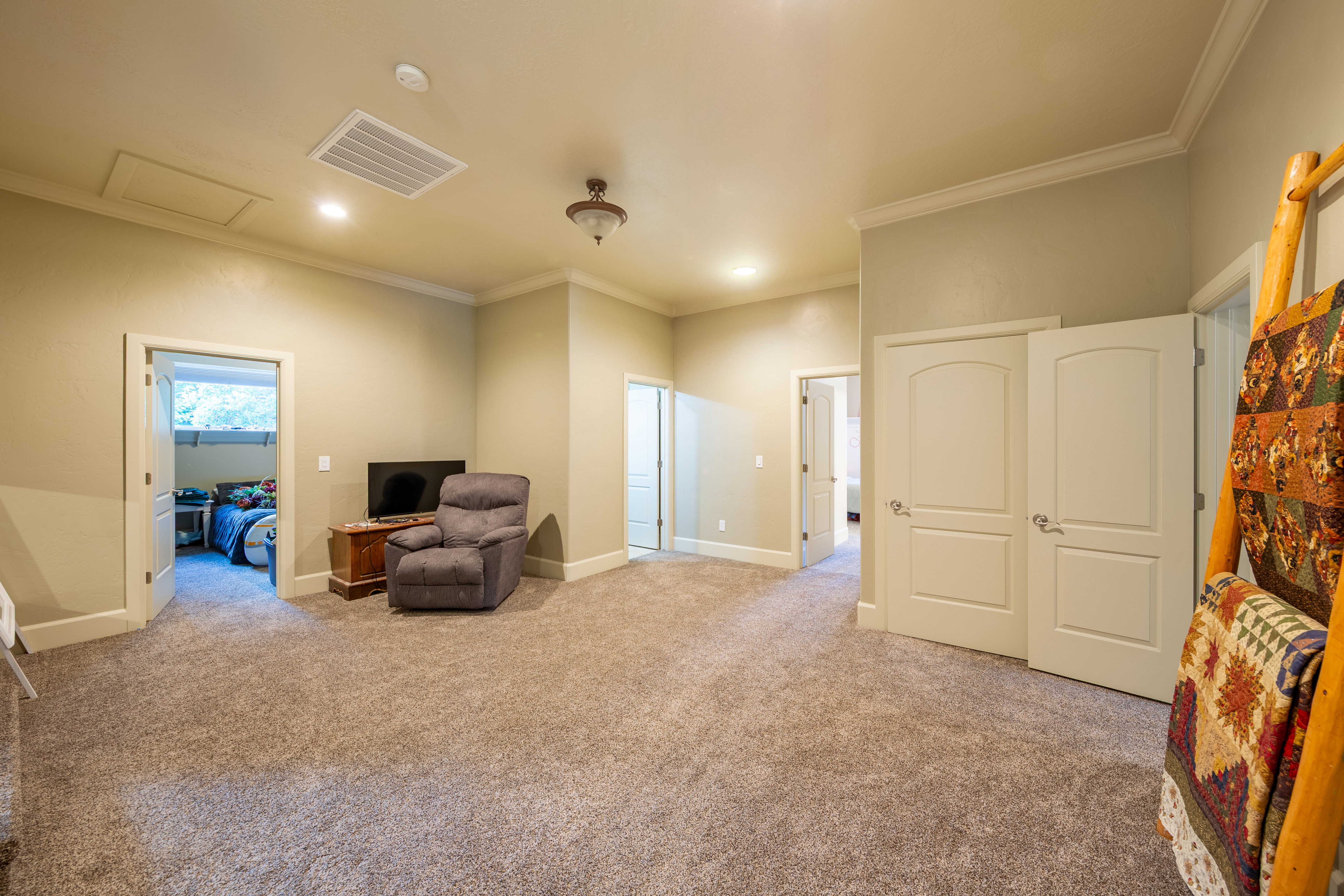 Spacious multi-purpose room featuring plush carpet flooring, recessed lighting, and crown molding