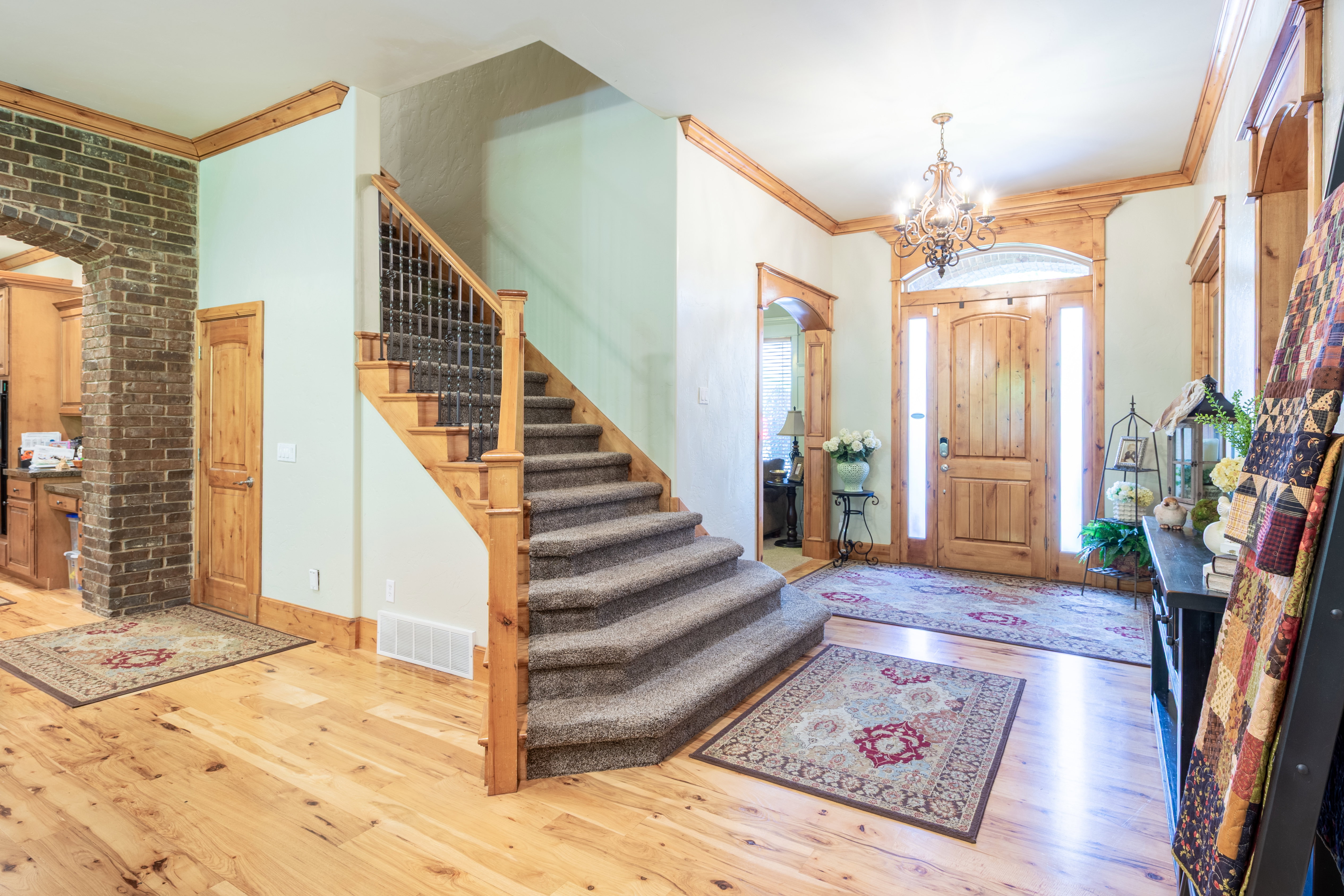 Foyer featuring a grand staircase with carpeted treads and wrought iron balusters