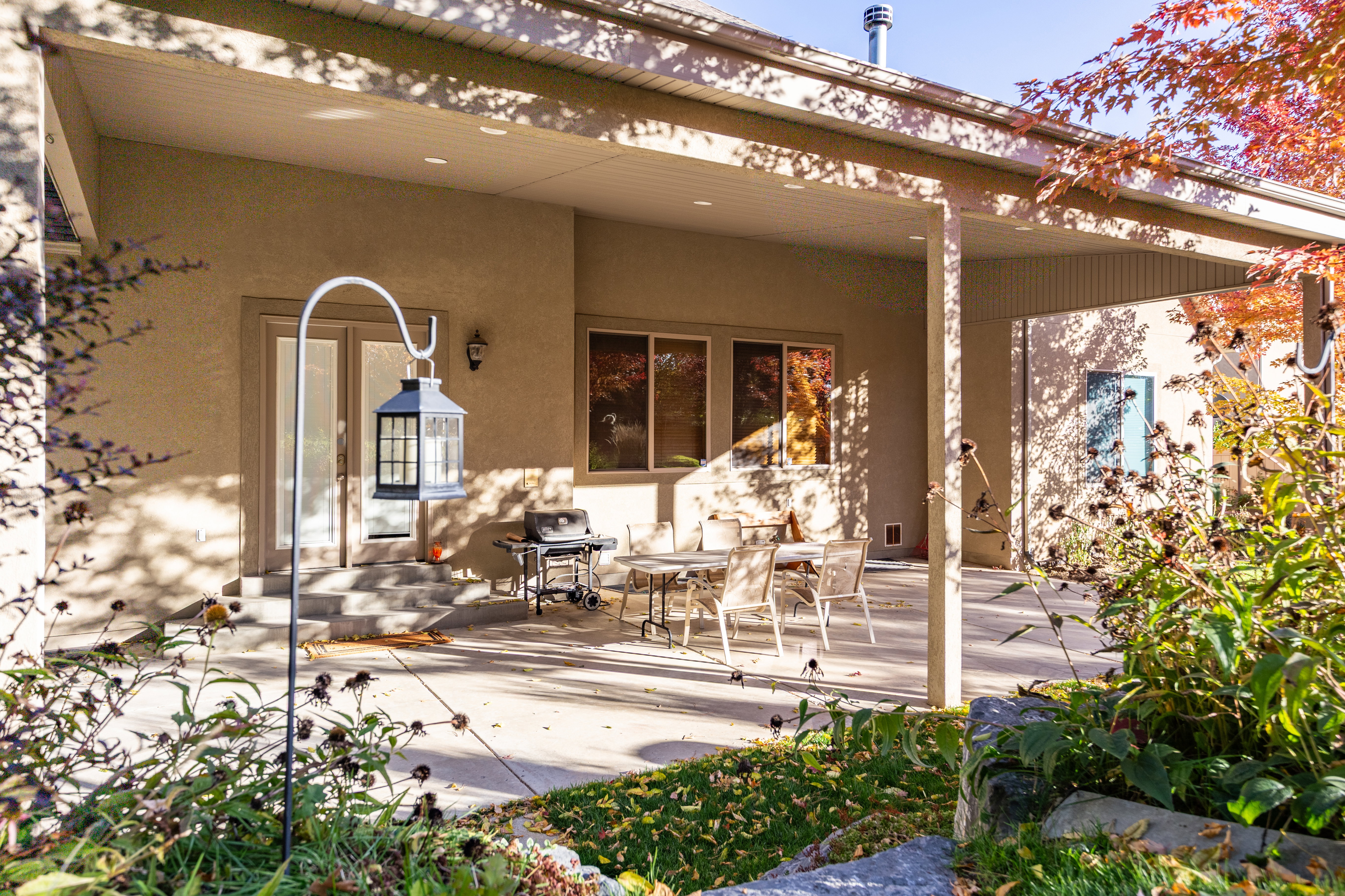 Expansive covered patio featuring a concrete surface, stucco exterior, and dual glass French doors