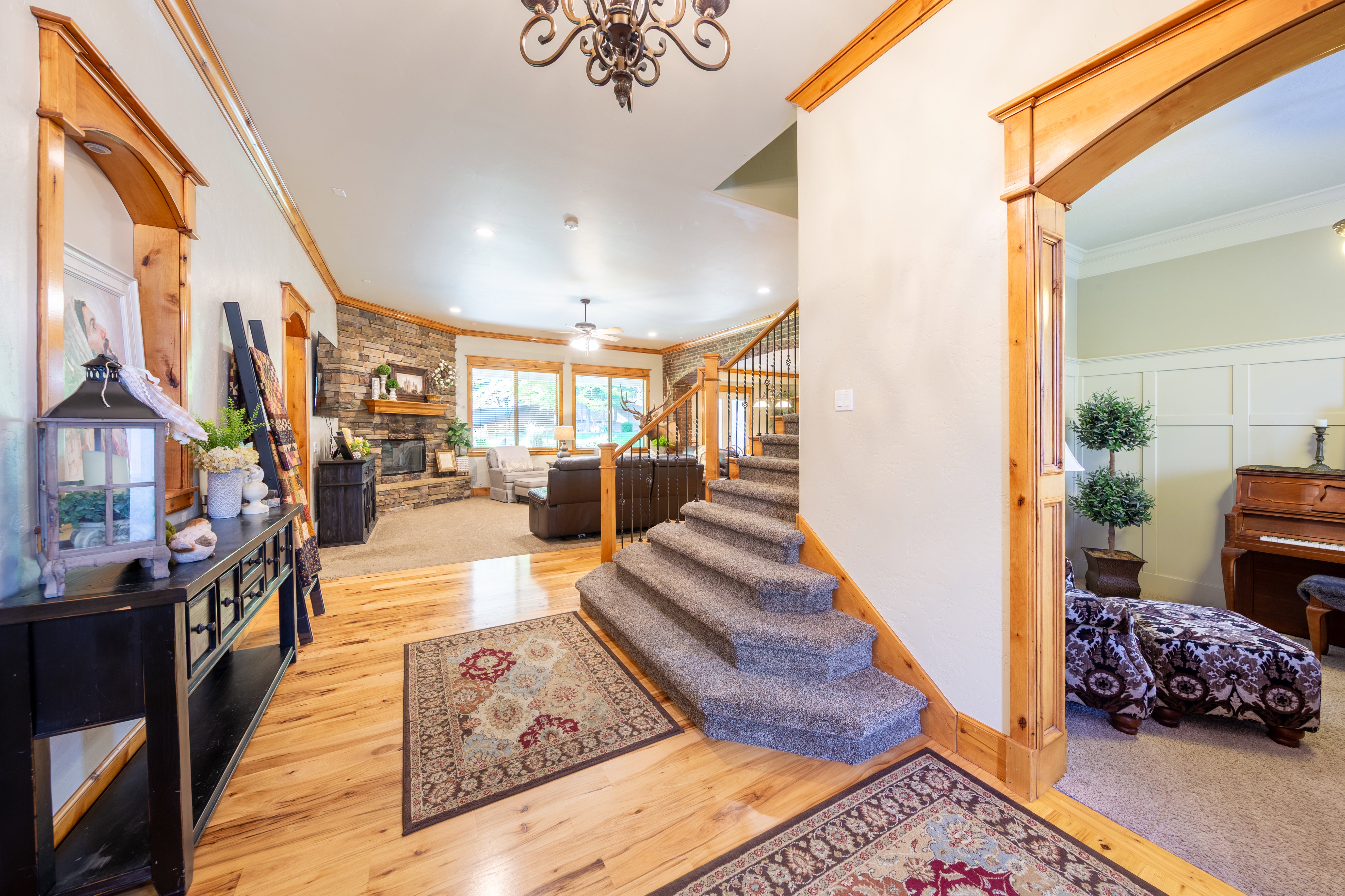 Foyer with wood-finish flooring and a carpeted staircase featuring a wrought iron railing