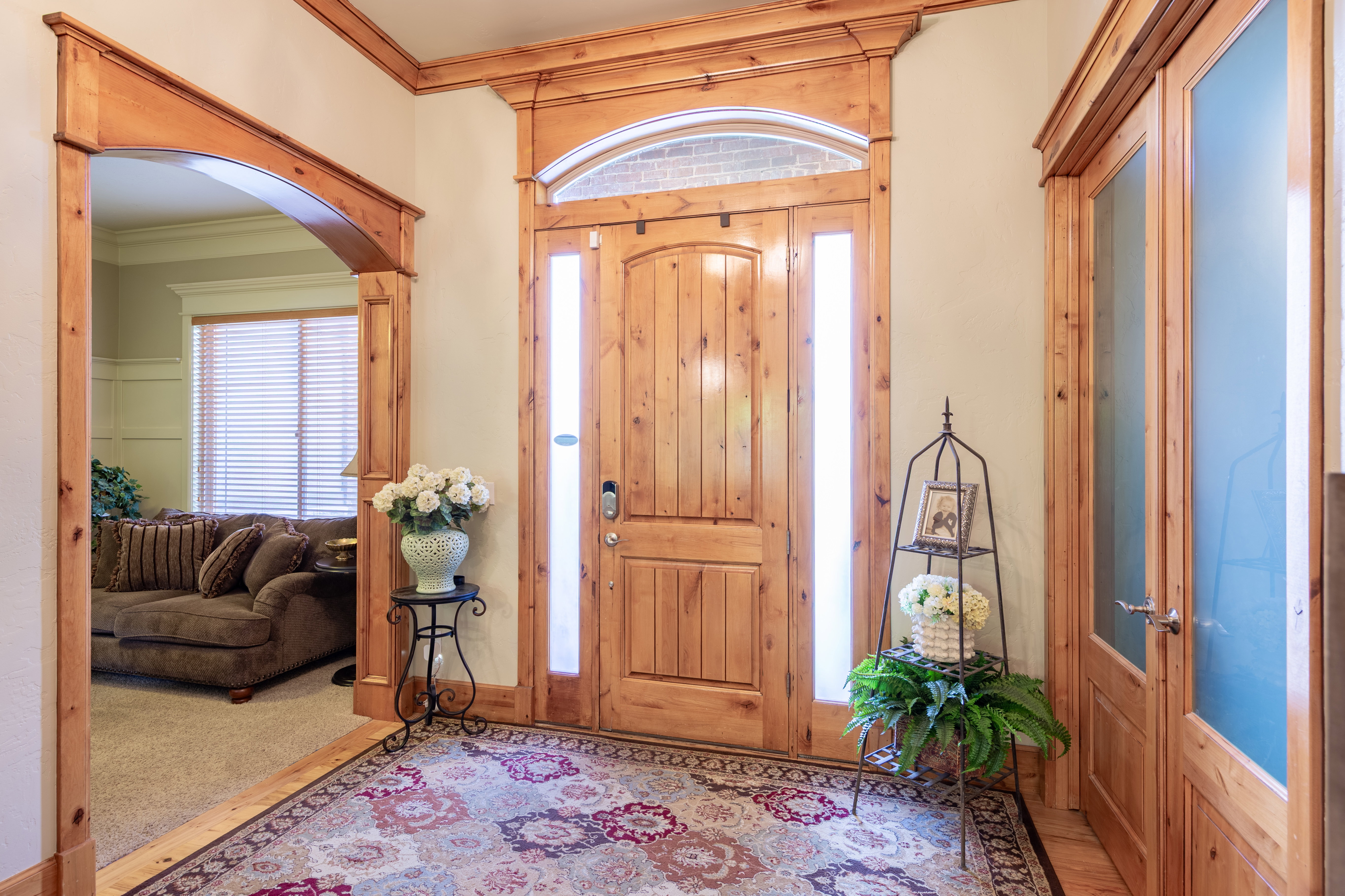 Grand entryway featuring a solid wood door with an arched transom and sidelight windows