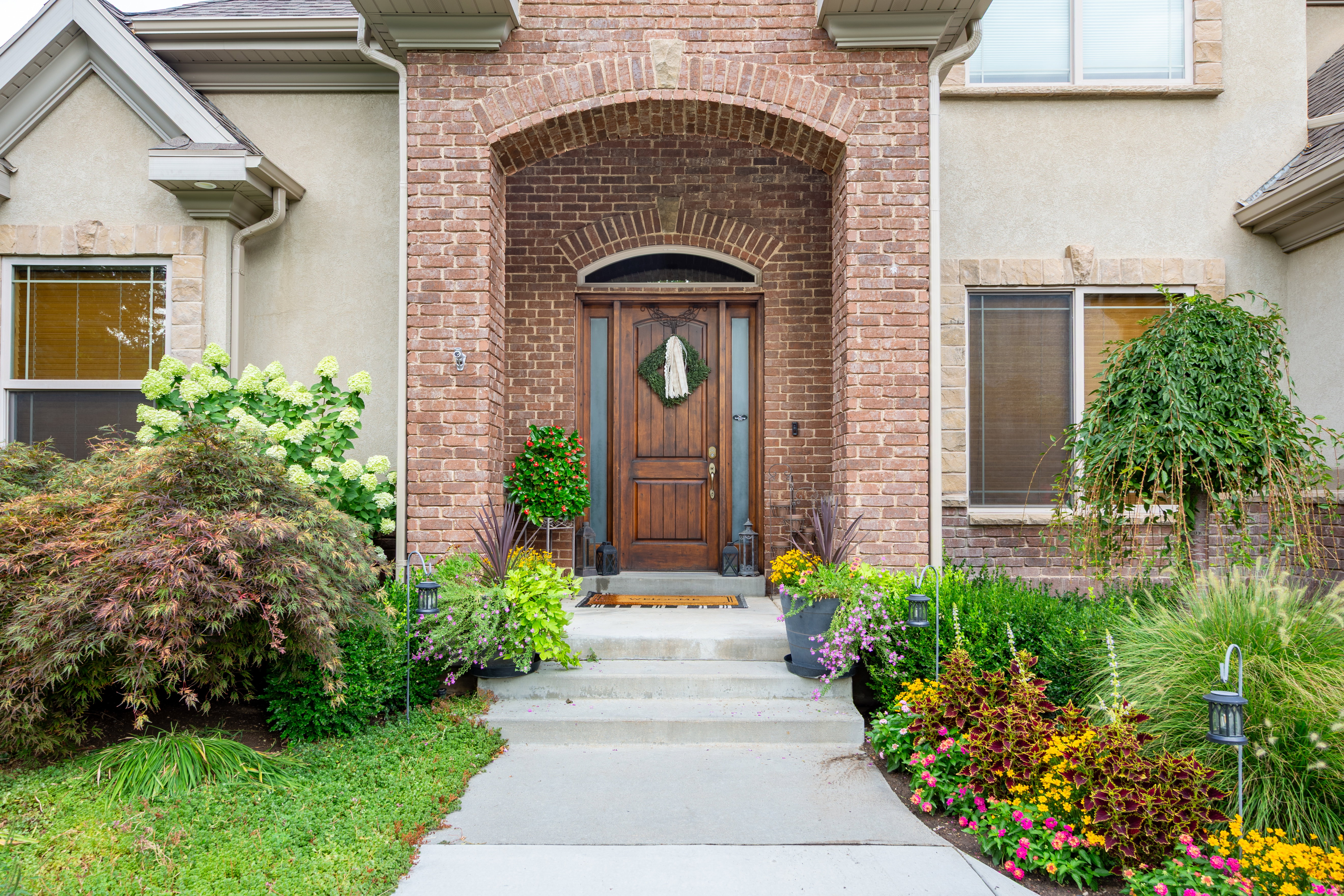 Stucco and brick exterior featuring an arched entryway