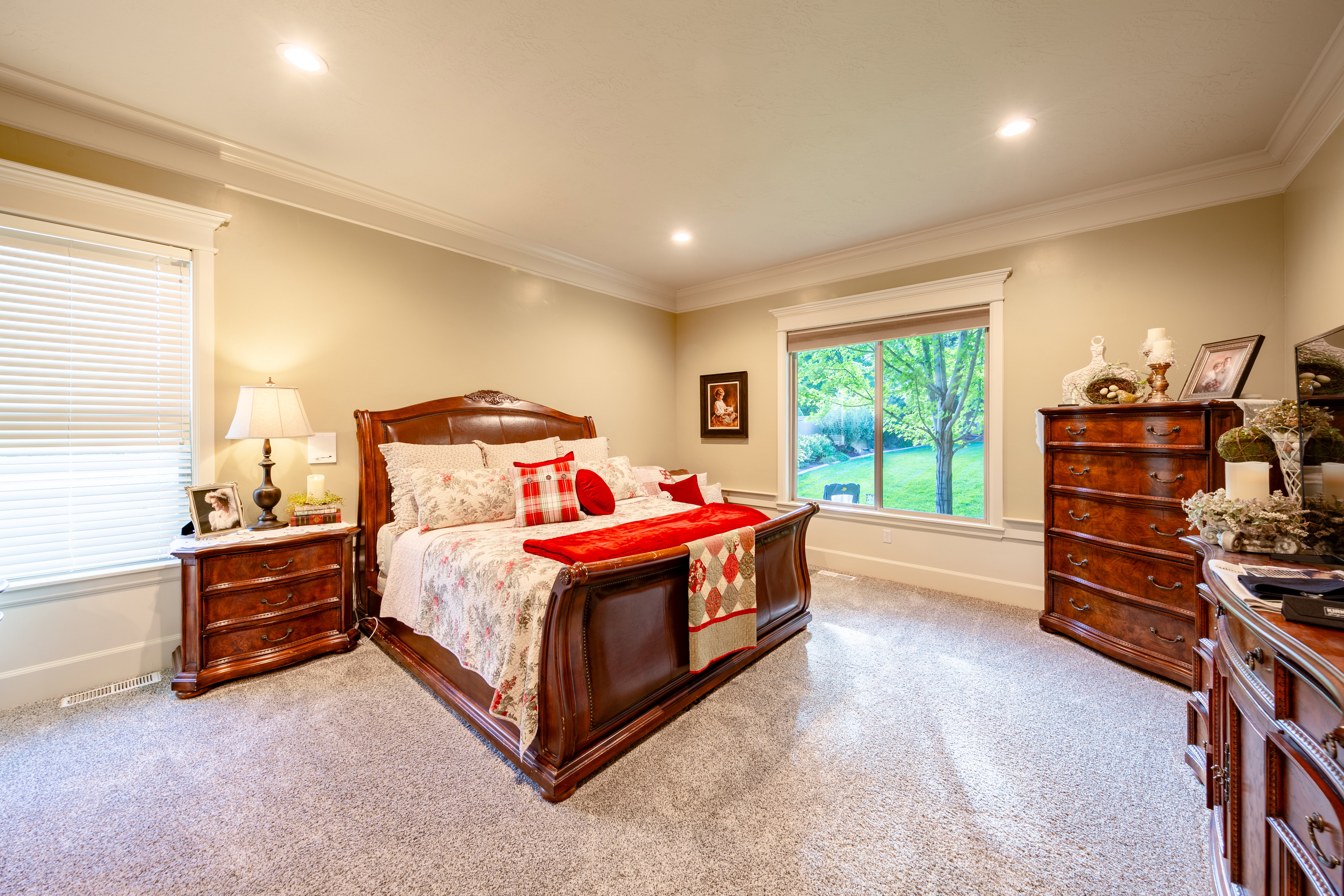 Spacious room featuring light gray carpeting, recessed lighting, white crown molding, and two white-trimmed windows