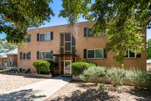 Brick exterior featuring black window shutters and a prominent glass entry