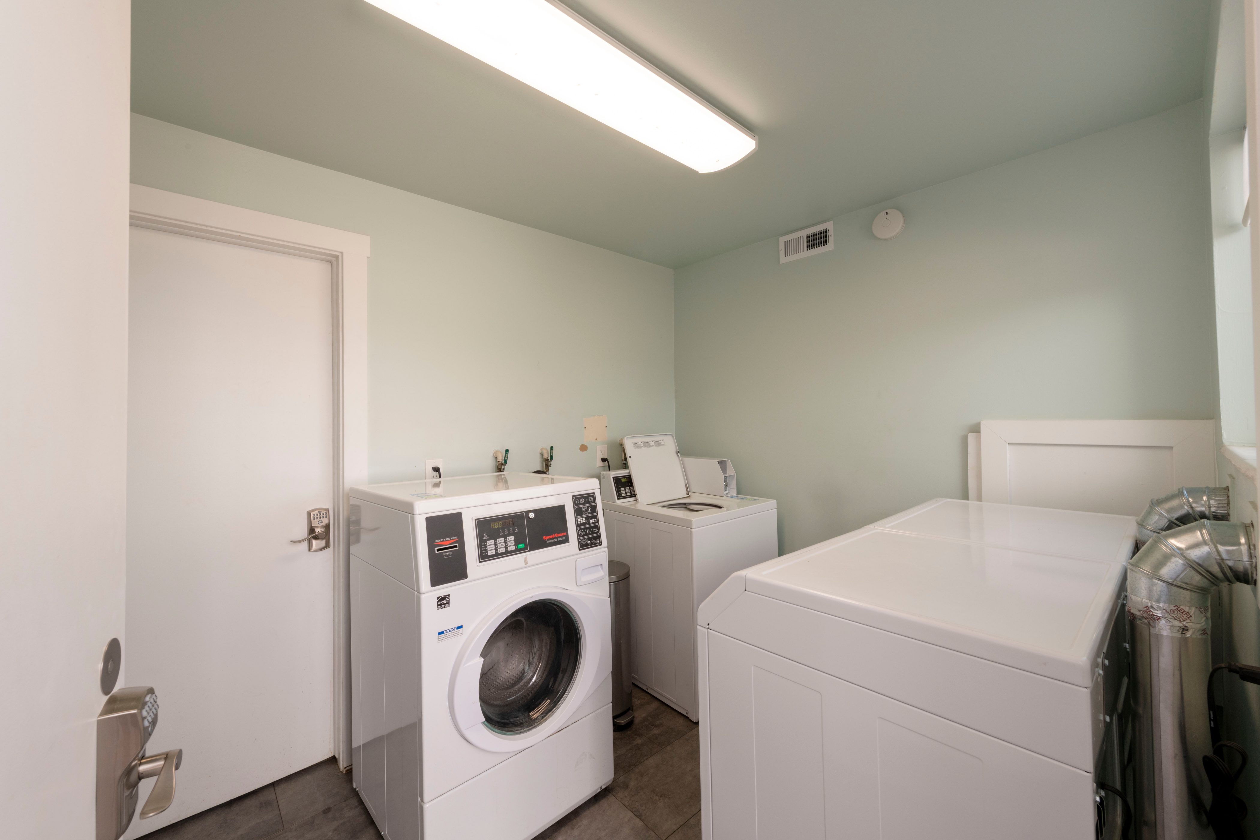 Dedicated laundry area featuring multiple washing machines and dryers