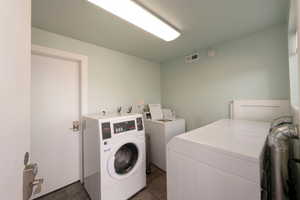 Dedicated laundry area featuring multiple washing machines and dryers