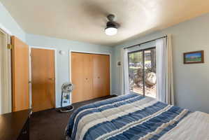 Sliding glass door access to exterior, ceiling fan with integrated lighting, wood-finish bi-fold closet doors, and wood-finish interior doors