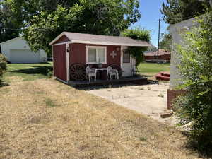 Red-painted outbuilding with white trim and a gabled roof