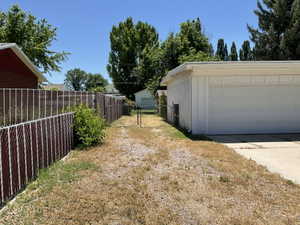 Detached garage structure featuring a paneled overhead door and decorative siding details
