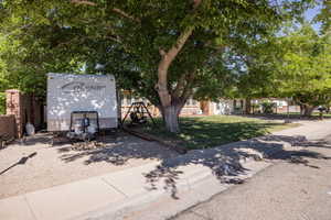 Gravel parking area featuring a brick privacy wall