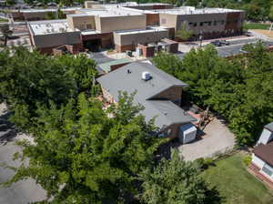 Single-story residence featuring a gray metal roof, brick exterior, and an expansive gravel driveway