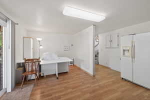 Spacious room featuring wood-finish flooring, white walls, and a recessed ceiling light