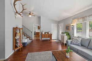 Living area featuring wood-finish flooring, vaulted ceilings, and a ceiling fan