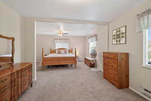 Carpeted bedroom area featuring light-toned walls and windows with blinds