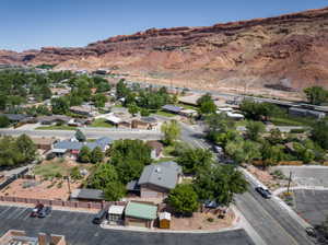 Elevated perspective showcasing a residential area framed by a natural rock formation and a clear blue sky