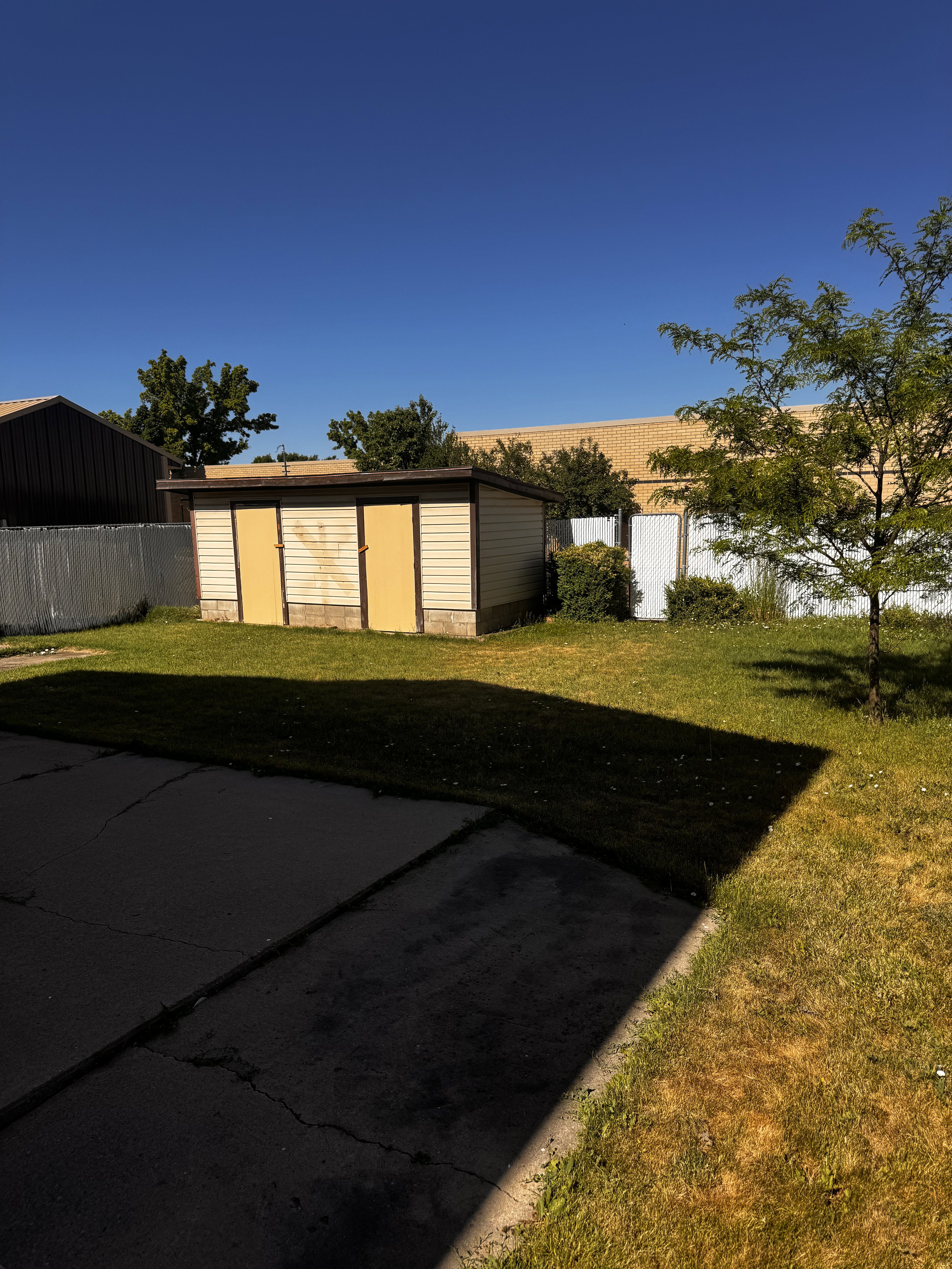 Detached storage shed featuring horizontal siding and dual yellow doors