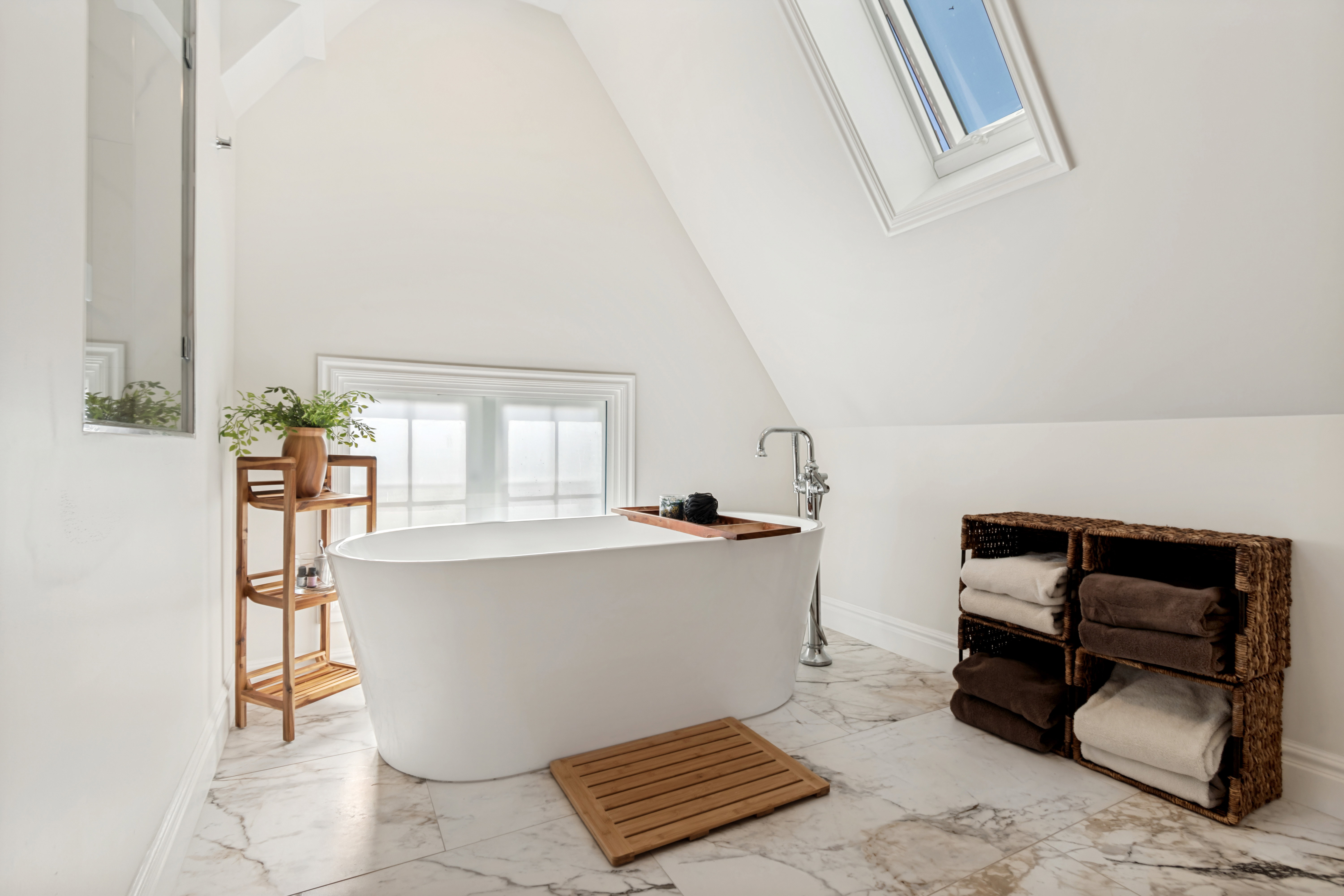 Freestanding soaking tub with floor-mounted chrome fixture