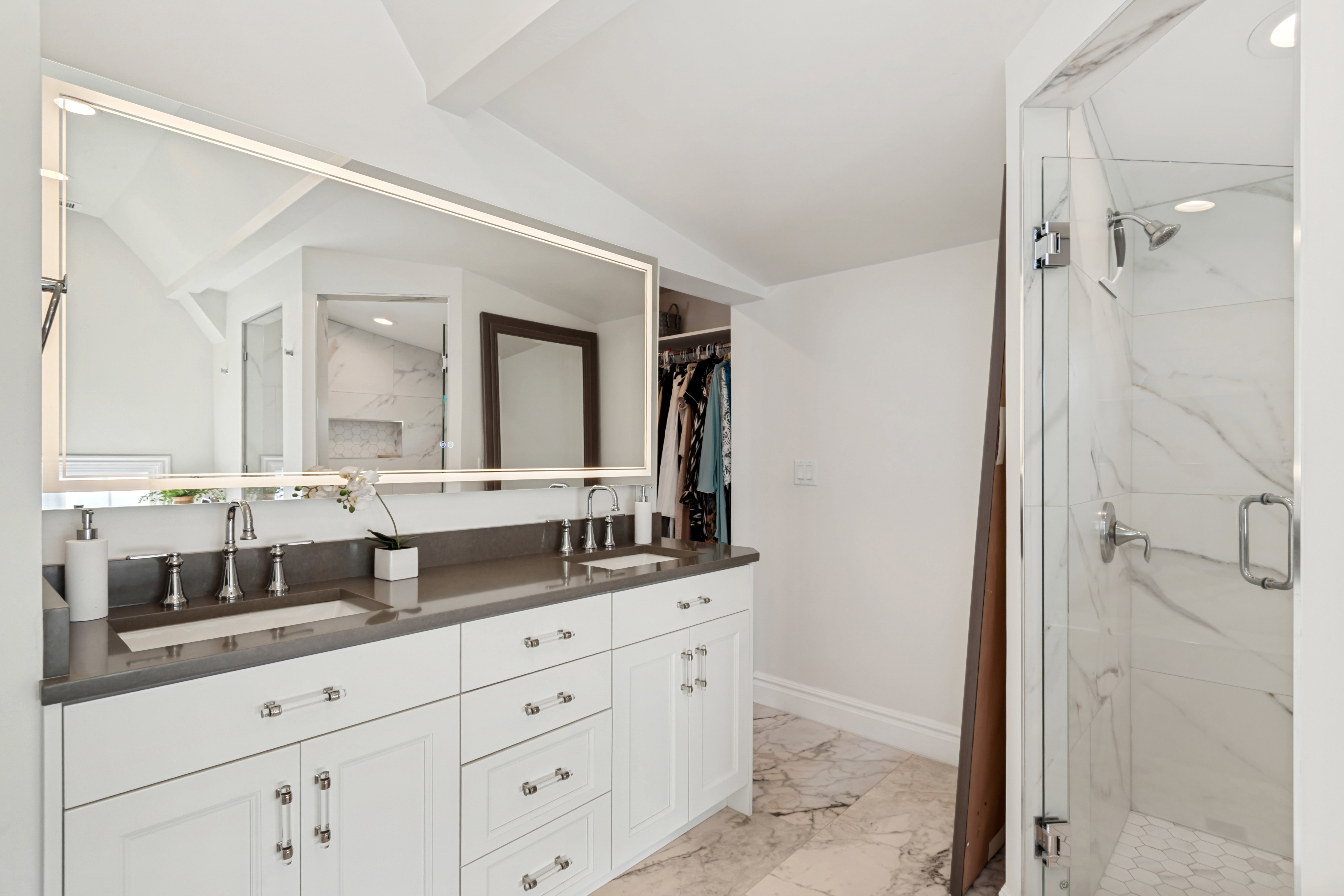 Double vanity featuring white cabinetry, integrated sinks, and a stone countertop