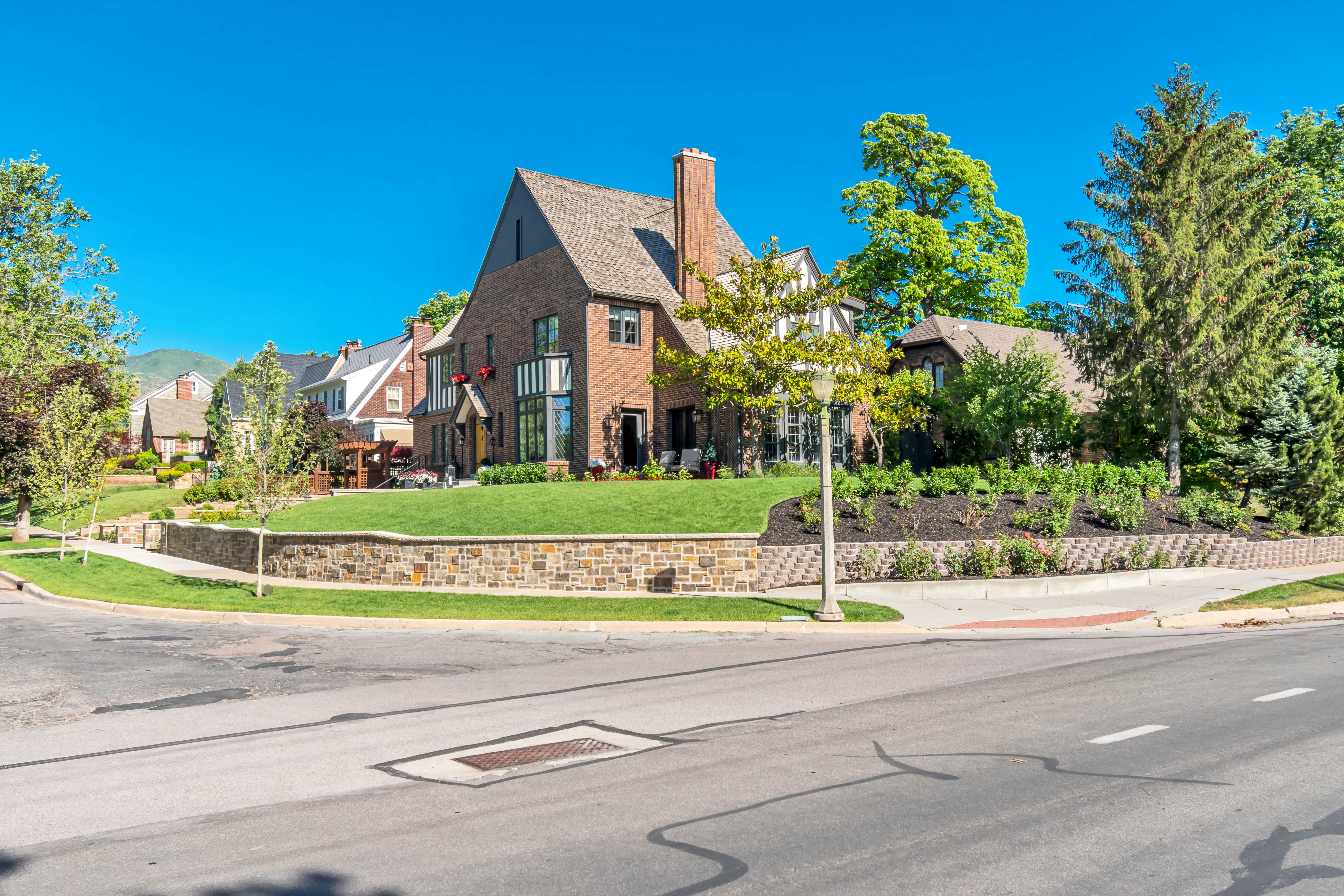 Brick and stucco exterior featuring a prominent chimney, gabled roofline, and large windows