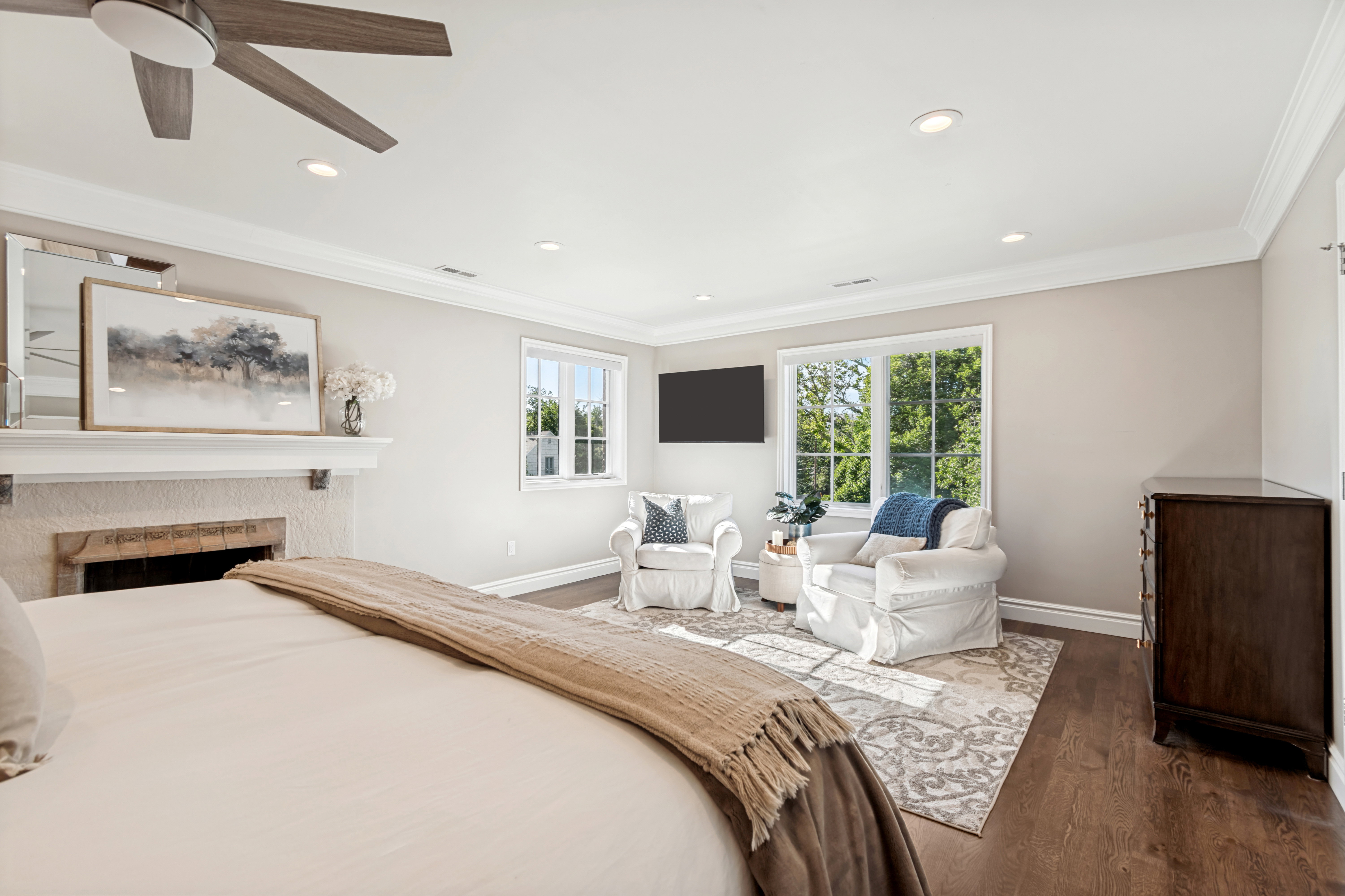 Spacious room featuring rich wood-finish flooring, a ceiling fan, and recessed lighting