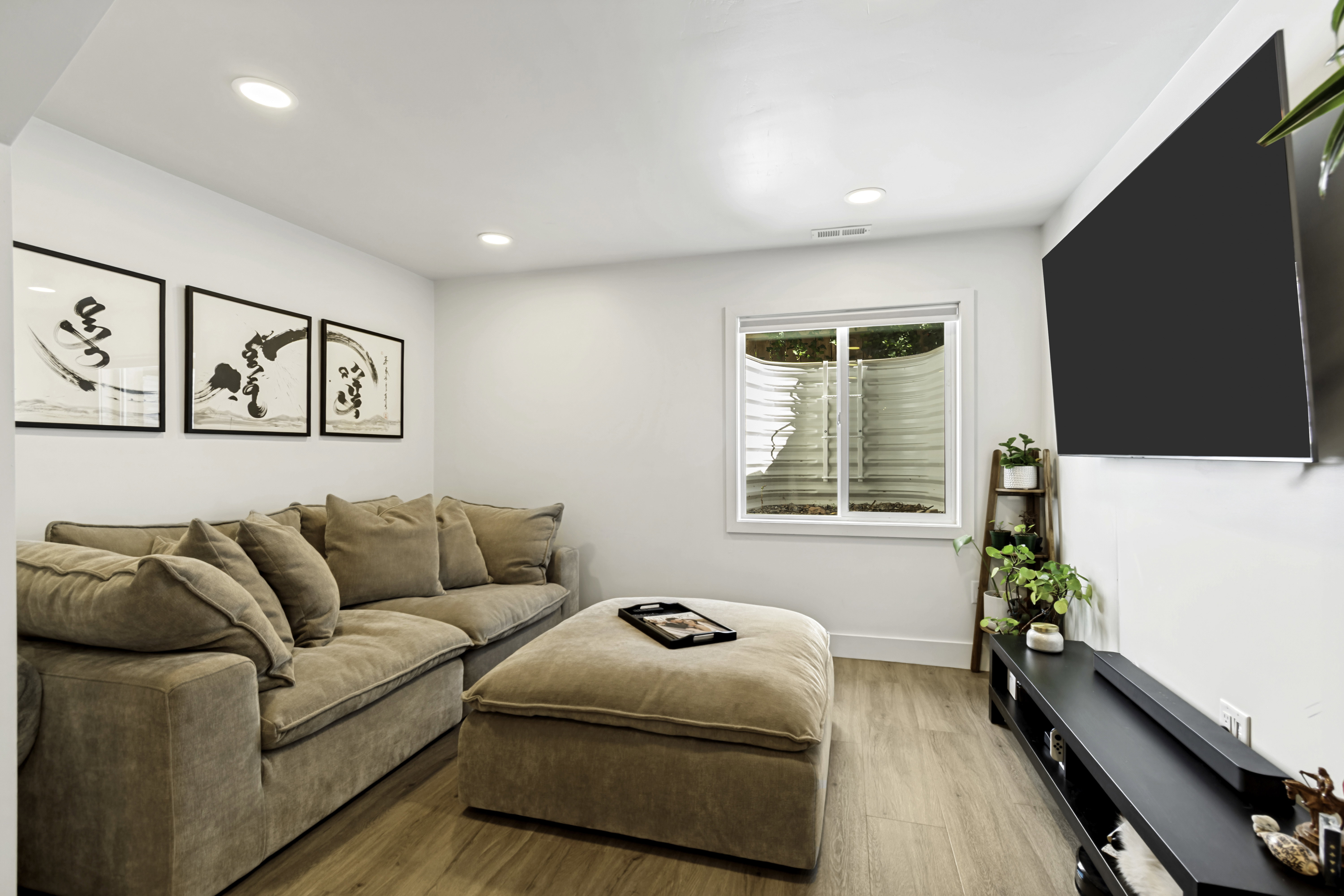 Recreation room featuring wood-finish flooring, recessed lighting, and a white-trimmed window
