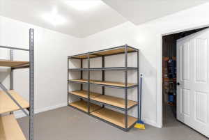 Dedicated storage room featuring two industrial-style shelving units, painted white walls, and a light gray floor