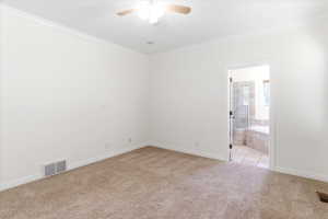 Carpeted room featuring white walls, crown molding, and a ceiling fan