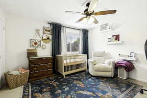 Windowed room featuring a ceiling fan with integrated lighting, wall-mounted shelving, and light-toned wall paint