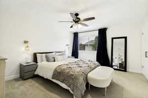 Neutral wall paint and carpeted flooring define this room, featuring a window with dark drapery