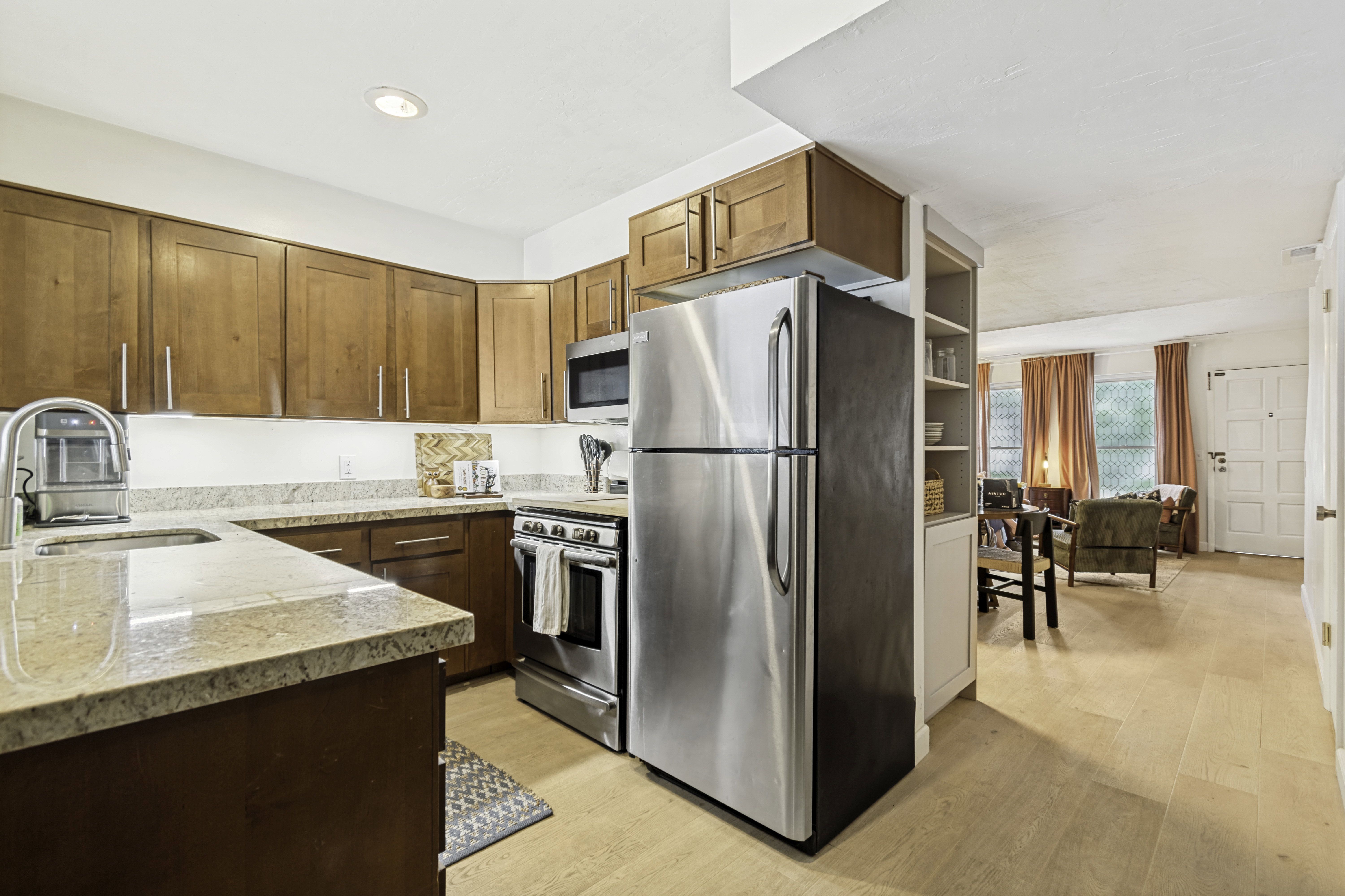 Kitchen featuring wood cabinetry, light-toned countertops, and stainless steel appliances