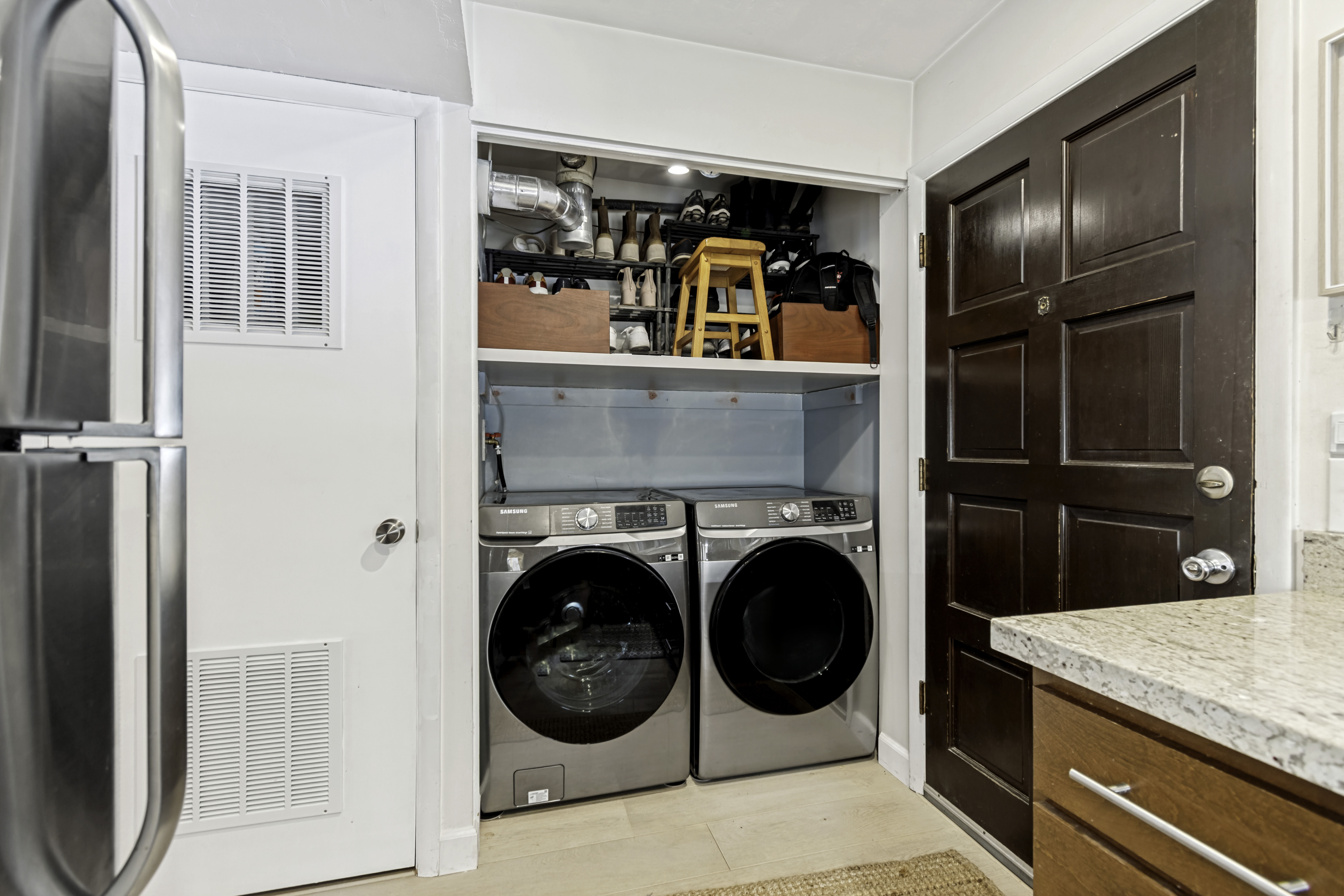 Integrated laundry closet featuring a stacked washer and dryer