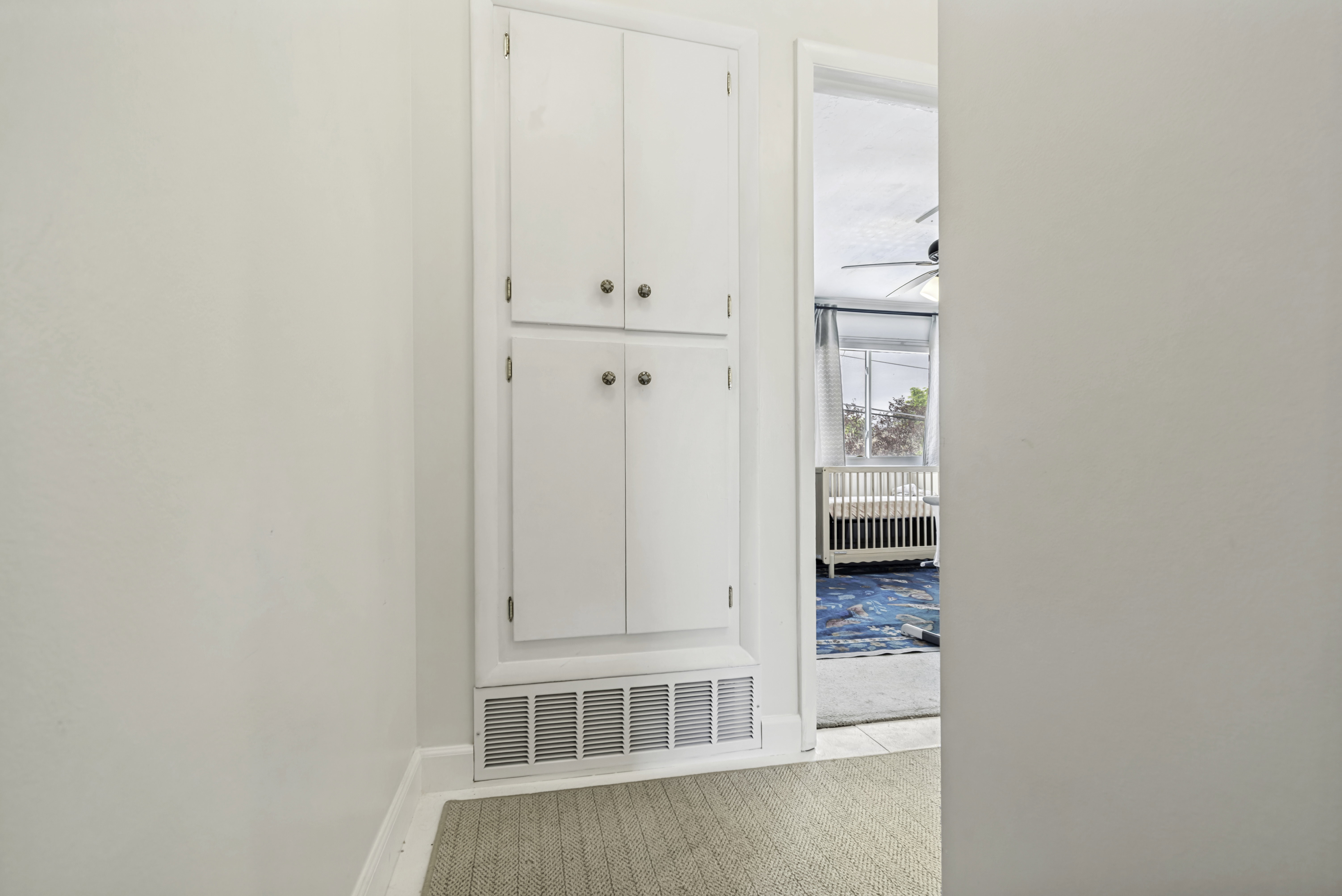 Built-in white cabinetry featuring four doors and brass-tone hardware