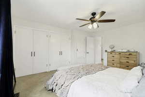 Interior room featuring light-colored carpeting, a ceiling fan with light fixture, and white walls