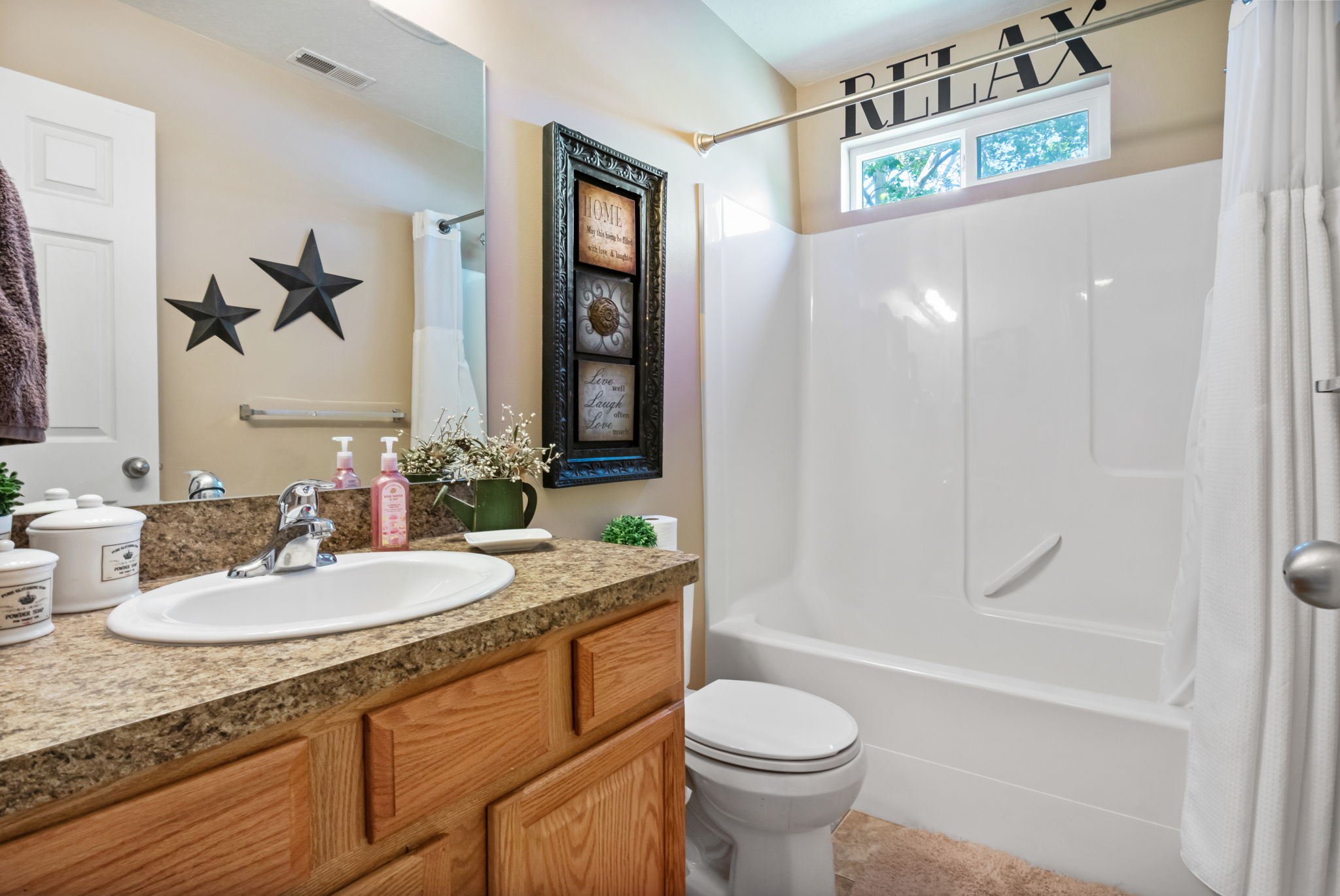 Full guest bathroom featuring a vanity with a countertop, an undermount sink, and wood-finish cabinetry