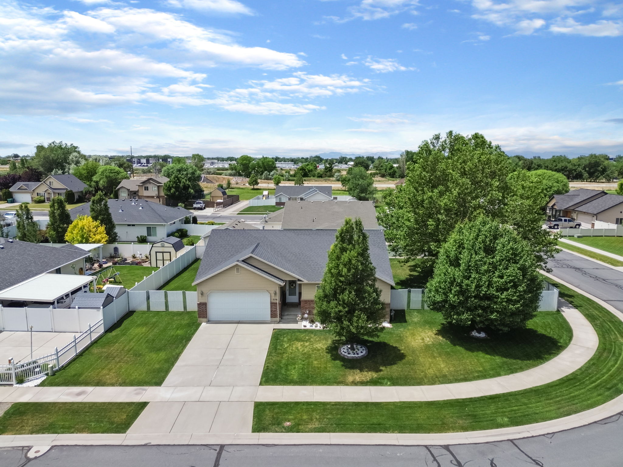 Single-story residence featuring a two-car garage, concrete driveway, and a front yard with mature landscaping