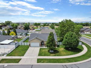 Single-story residence featuring a two-car garage, concrete driveway, and a front yard with mature landscaping