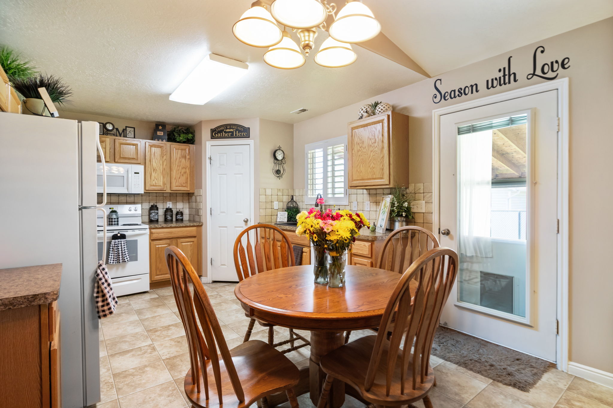 Kitchen featuring wood-finish cabinetry, tile flooring, and a white appliance suite