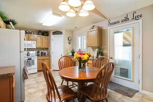 Kitchen featuring wood-finish cabinetry, tile flooring, and a white appliance suite