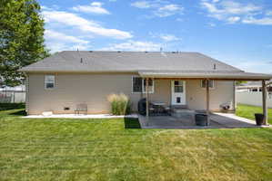Spacious backyard featuring a covered patio, extensive lawn, and gravel landscaping