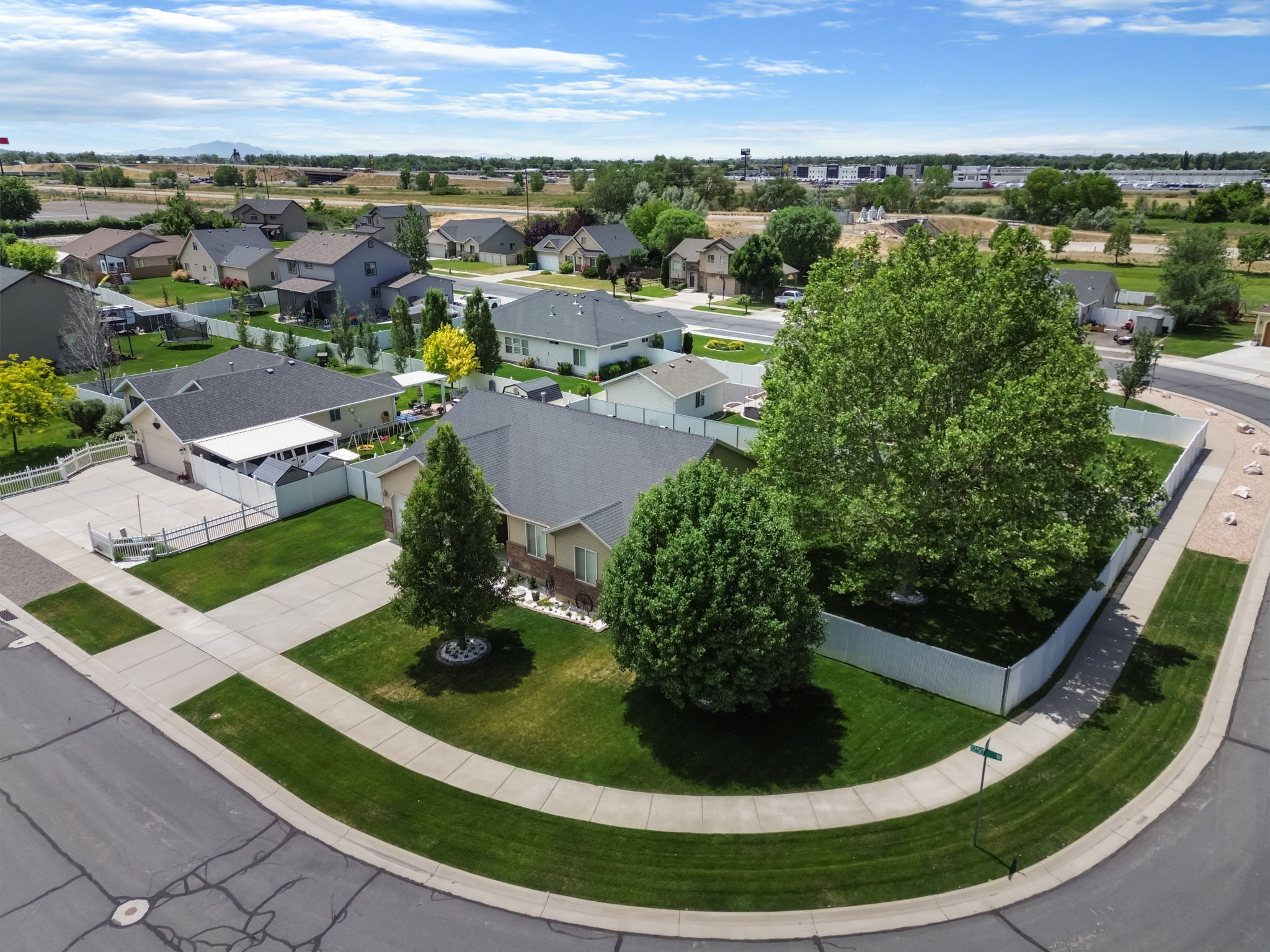Corner lot property featuring mature trees and a manicured lawn