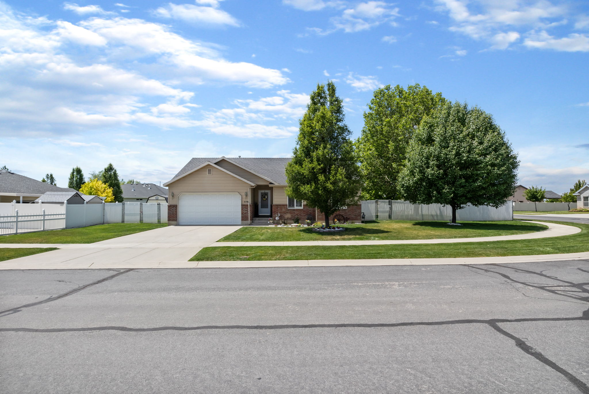Single-story residence featuring a two-car garage, partial brick facade, and a paved driveway