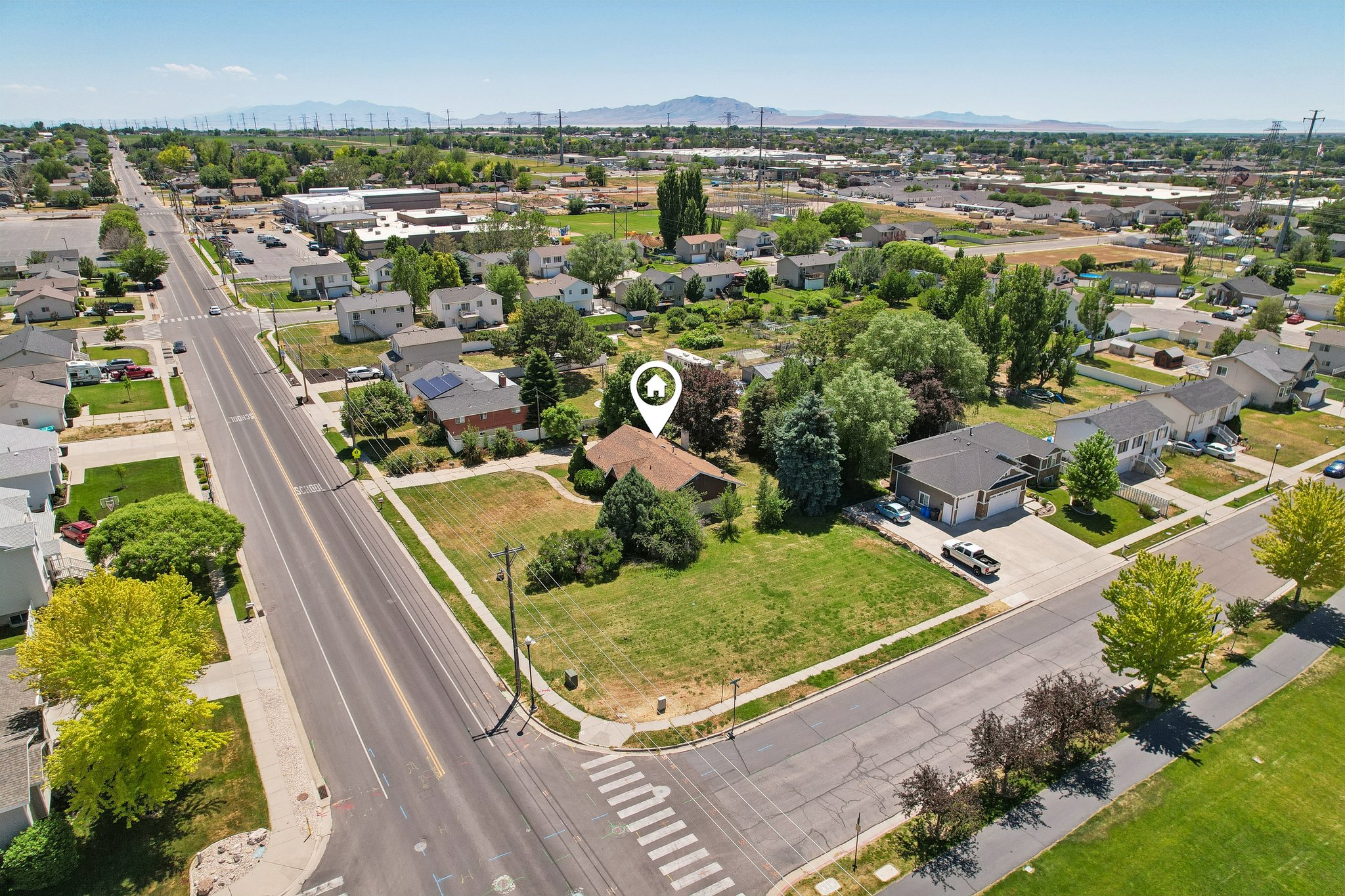 Corner lot property featuring a single-story residence with a brown roof