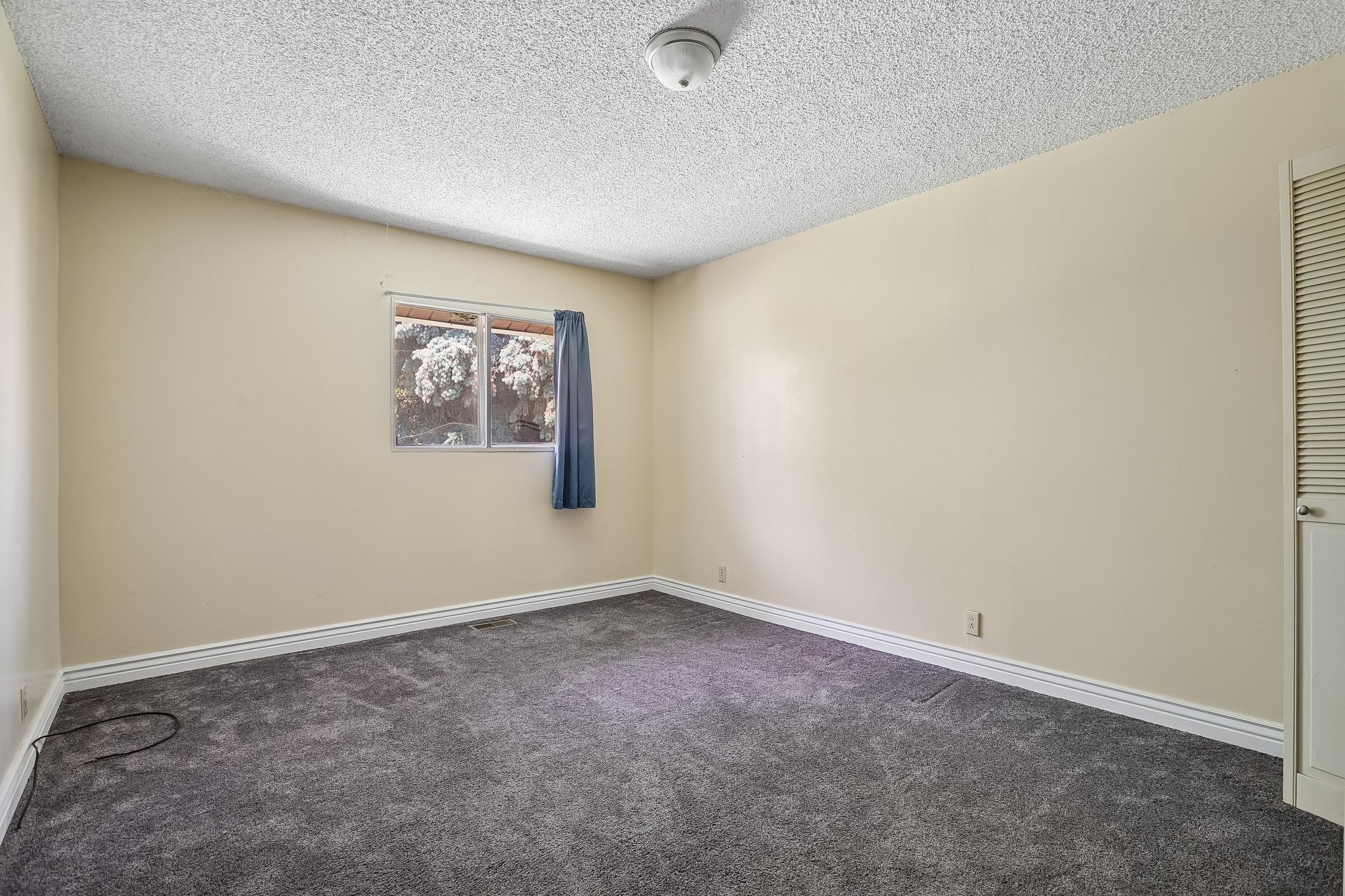 Room featuring neutral wall paint, grey carpeting, and white baseboards
