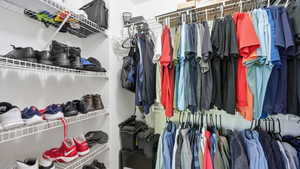 Custom closet system featuring white wire shelving, multiple hanging rods, and integrated shoe storage