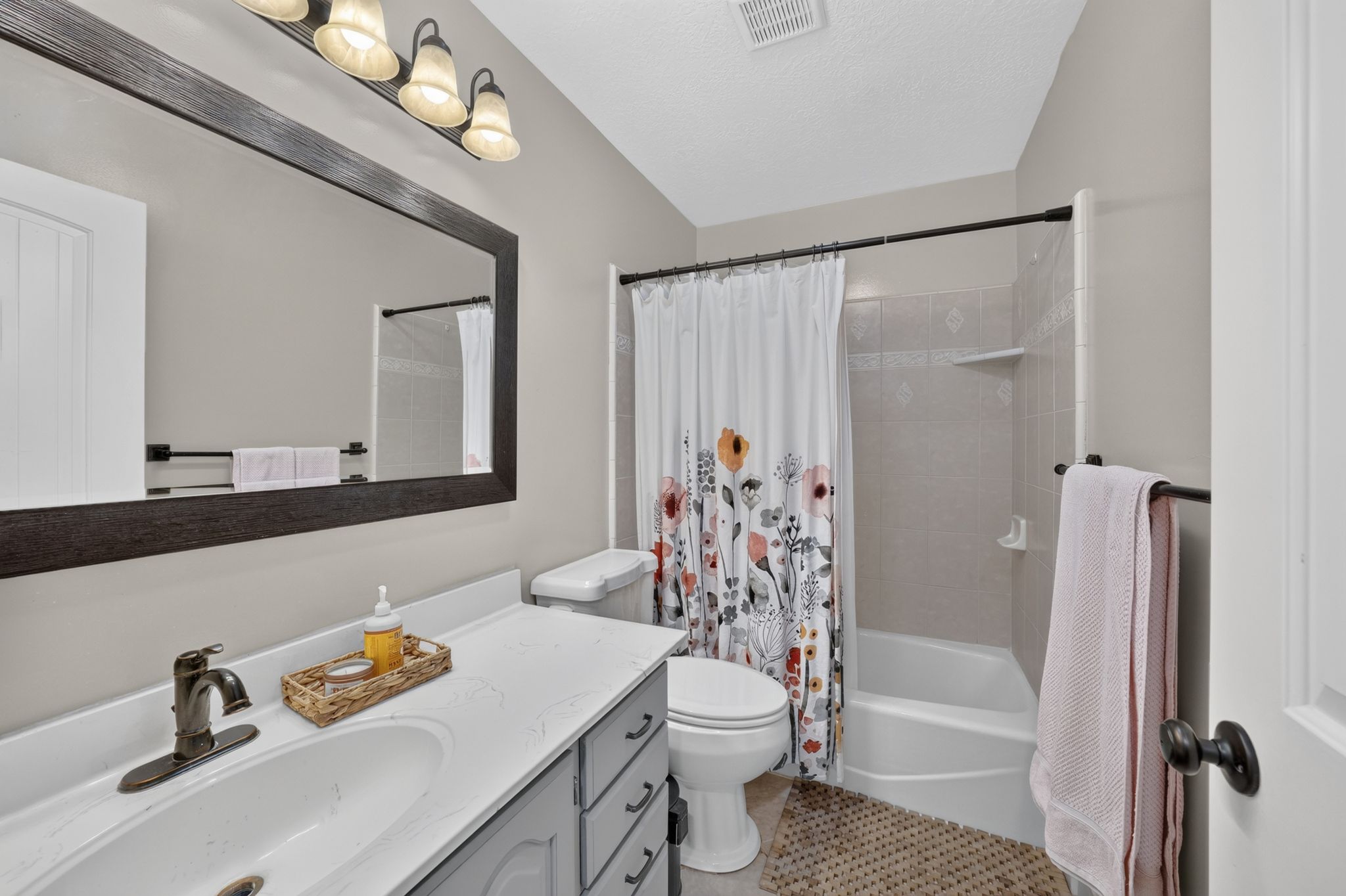 Bathroom vanity featuring a single basin sink, bronze-finish faucet, and white countertop