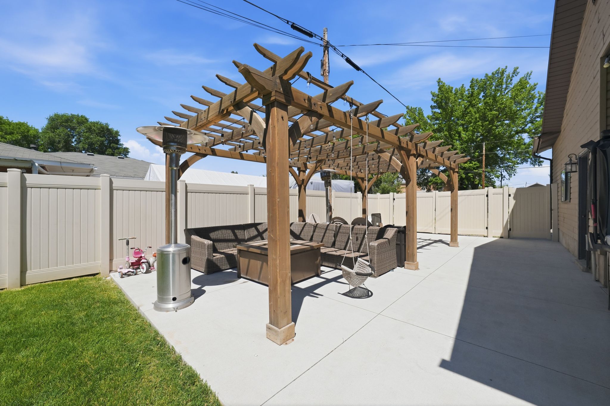 Spacious concrete patio with an extensive wooden pergola