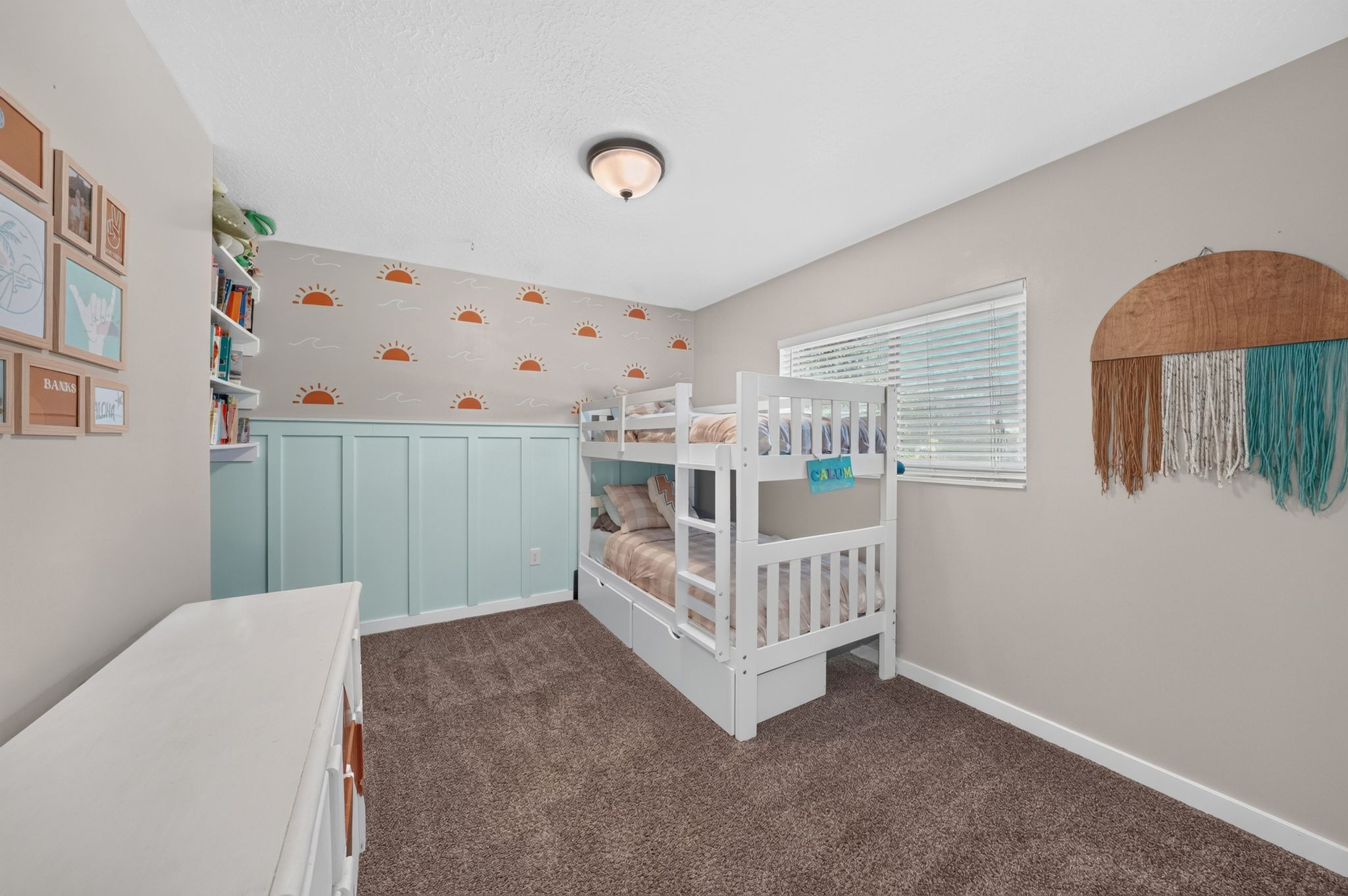 Room featuring a window with horizontal blinds, built-in shelving, board and batten wall paneling, and wall-to-wall carpeting