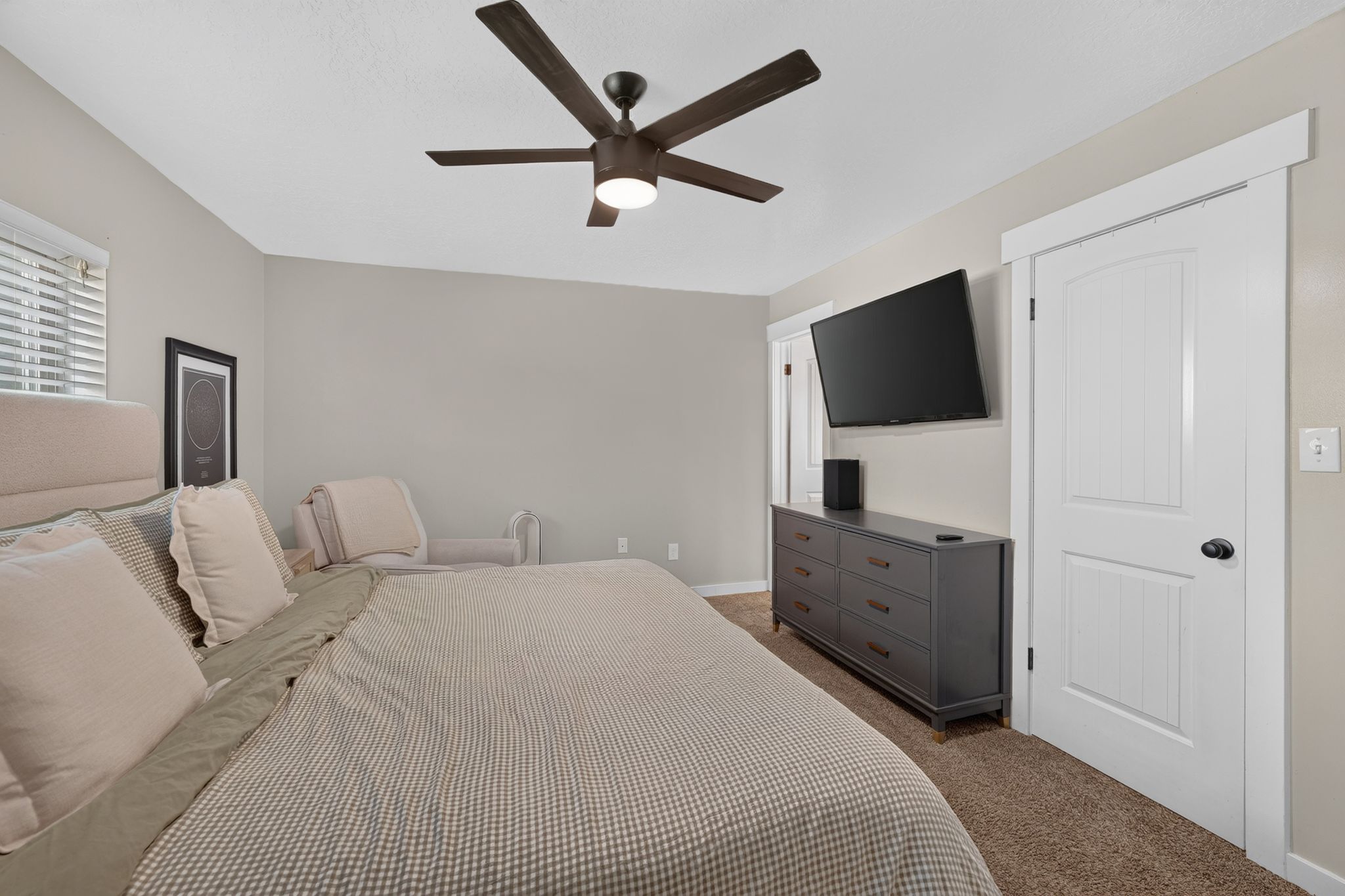 Primary Bedroom featuring neutral wall tones, textured carpet flooring, and a ceiling fan with integrated lighting