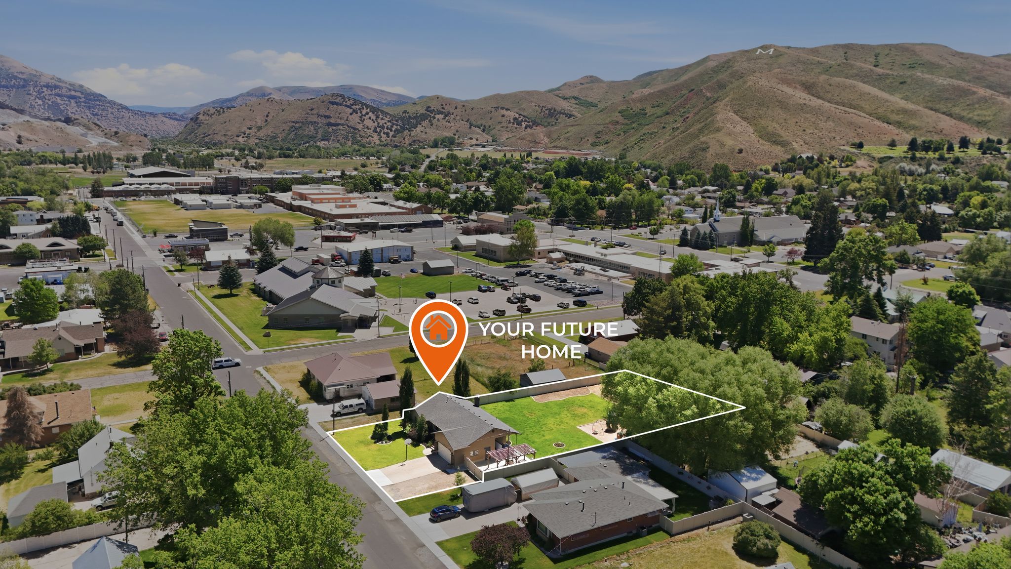 Aerial view showcasing a property with a spacious green lawn, mature trees, and a paved driveway