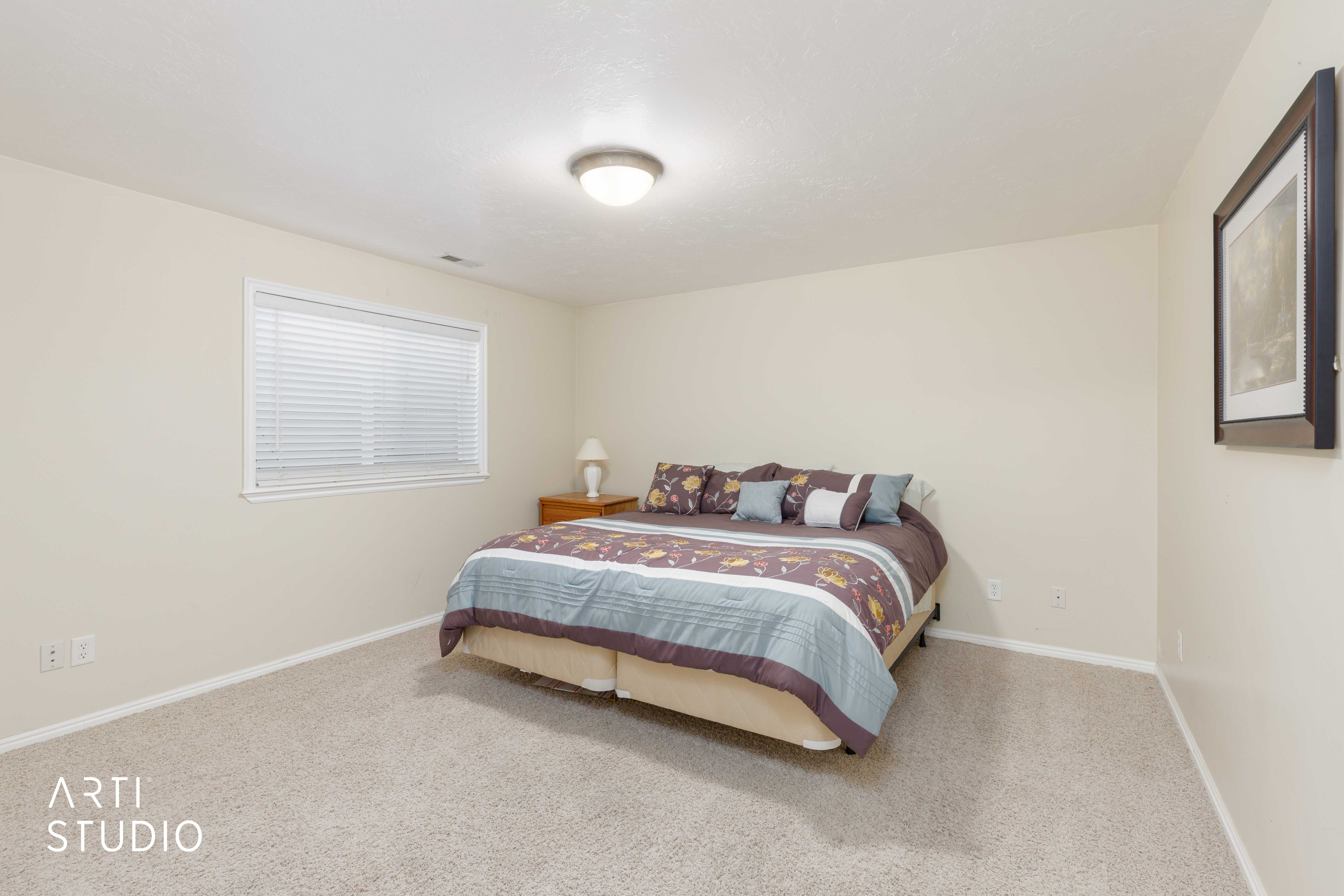 Carpeted room featuring a single window with blinds, a flush-mount ceiling light fixture, and neutral-toned walls